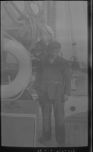 Image of Man standing on deck by mast